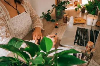 Woman working at home office desk with crystals for focus and productivity