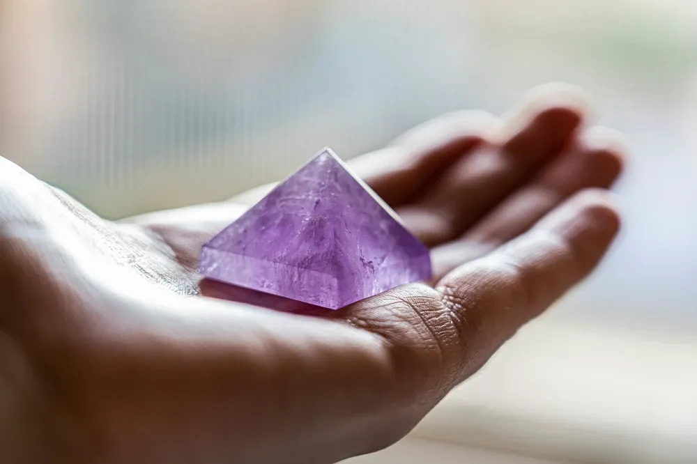 person holding the Amethyst pyramid