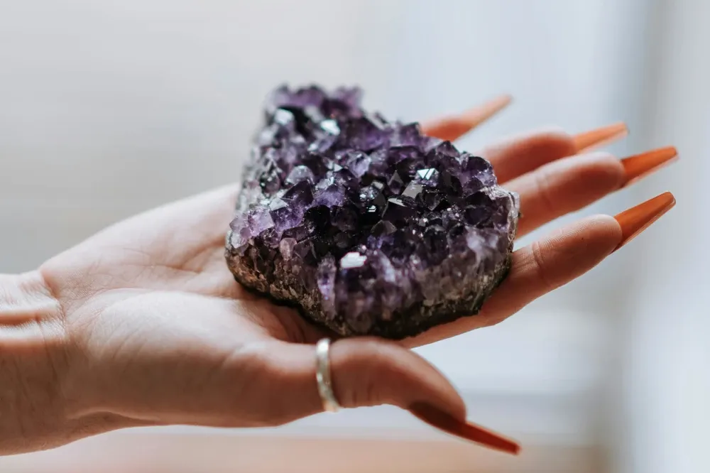 women holding raw amethyst geode 